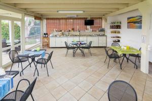 ein Zimmer mit Tischen und Stühlen sowie einer Küche in der Unterkunft Agriturismo Un Posto al Sole in Otranto