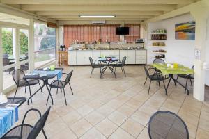 a room with tables and chairs and a kitchen at Agriturismo Un Posto al Sole in Otranto