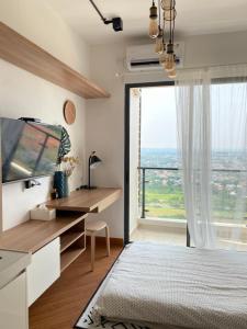 a bedroom with a desk and a large window at Skyhouse Bsd warm and cozy studio by lalerooms in Tangerang