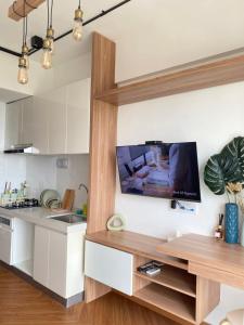 a kitchen with a flat screen tv on the wall at Skyhouse Bsd warm and cozy studio by lalerooms in Tangerang