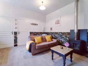 ein Wohnzimmer mit einem Sofa und einem Kamin in der Unterkunft Uw eigen boerderij bij Le Moulin de la Place in Hargicourt