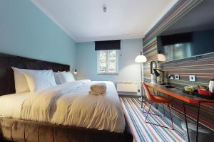 a bedroom with a large bed and a desk at Village Hotel Leeds North in Leeds