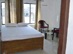 a bedroom with a bed and a chair and a window at PAGODAINN in Konārka