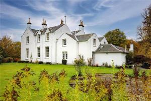 uma grande casa branca com um jardim verde em Park of Drumquhassle em Glasgow