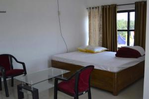 a bedroom with a bed and a table and chairs at PAGODAINN in Konārka