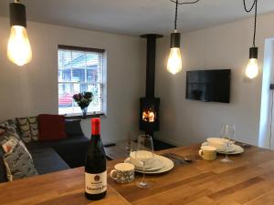 uma sala de estar com uma mesa e uma garrafa de vinho em Stable Cottage em Matlock