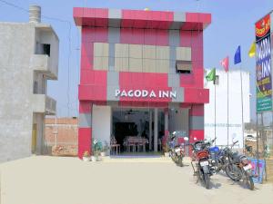 a building with two motorcycles parked in front of it at PAGODAINN in Konārka