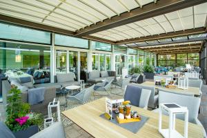 a restaurant with chairs and tables and windows at Hotel Regina Maris in Norddeich