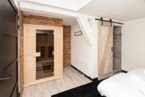 a room with a bed and a sliding barn door at Bomont appartementen 2 persoons - Jan van Renesseweg 1 Renesse in Renesse