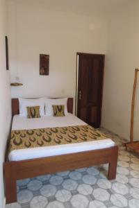 um quarto com uma cama grande e uma estrutura em madeira em Micaval Residential em São Tomé