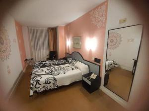 1 dormitorio con cama y espejo grande en Hotel Arha Santander, en Santander