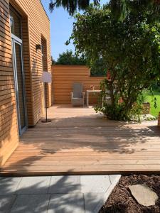 une terrasse couverte en bois avec une chaise sur une maison dans l'établissement Ferienhaus Ulme in Naunhof Leipziger Neuseenland, à Köhra