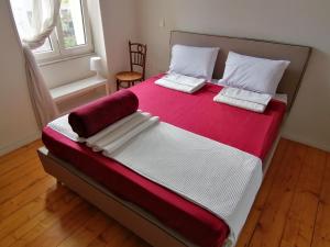 a bedroom with a large bed with red and white sheets at AcroView in Athens