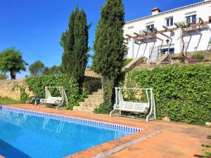 two white chairs sitting next to a swimming pool at Villa Casa Alta in Ronda