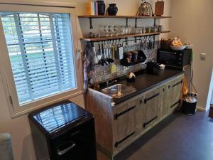 a kitchen with a counter and a sink and a window at Erve Het Roolvink Boerderij Appartementen 40-50 M2 in Enschede