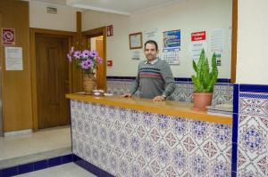 a man standing at a counter in a room at Pensión Pardo in Benidorm