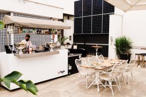 a restaurant with a table and chairs and a chef in the kitchen at Room Mate Anna, Barcelona in Barcelona