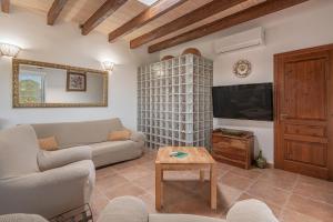 een woonkamer met een bank en een tv bij Villa Can Tomeu in Felanitx