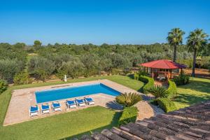 een uitzicht op een zwembad met stoelen en een prieel bij Villa Can Tomeu in Felanitx