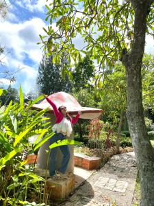 una mujer sosteniendo un paraguas en un jardín en Phumimalee Nature View Resort, en Nakhon Ratchasima