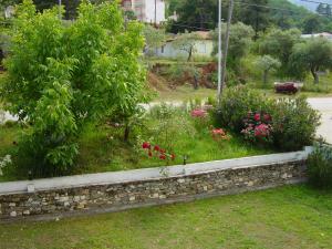 a garden with flowers and a stone wall at Blue Sky Villas in Skala Potamias