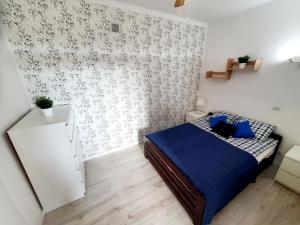 een slaapkamer met een bed met een blauw dekbed bij Apartament GOOD POINT - RYBAKI Gdańsk in Gdańsk