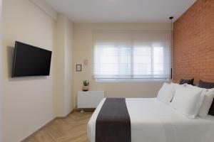 a bedroom with a large bed and a brick wall at Acropolis Premium Residence in Athens