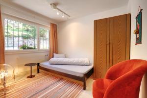 1 dormitorio con 1 cama, 1 silla y 1 ventana en Hotel Zarera, en Poschiavo