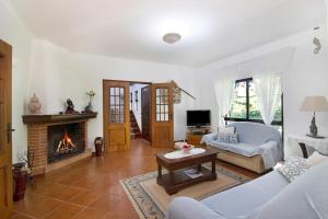 een woonkamer met een bank en een open haard bij Casa da Alfarrobeira in Loulé