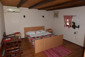een slaapkamer met een bed in de hoek van een kamer bij Etno Selo Moravski Konaci in Velika Plana