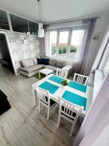 a living room with a table and chairs and a couch at Apartament GOOD POINT - RYBAKI Gdańsk in Gdańsk