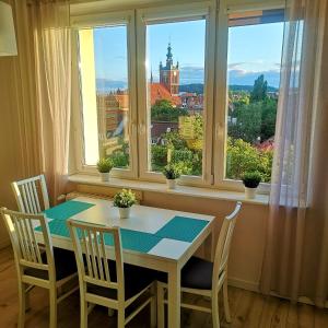mesa y sillas en una habitación con ventana en Apartament GOOD POINT - RYBAKI Gdańsk en Gdansk
