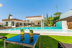 una mesa frente a una casa con piscina en Cubo's Villa Elena, en Alhaurín el Grande