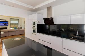 eine Küche mit weißen Schränken und schwarzen Geräten in der Unterkunft Cubo's Villa Elena in Alhaurín el Grande