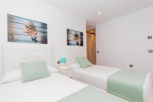 zwei Betten in einem Zimmer mit weißen Wänden in der Unterkunft Cubo's Villa Elena in Alhaurín el Grande + 78 Fotos