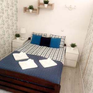 a small bedroom with a bed with blue pillows at Apartament GOOD POINT - RYBAKI Gdańsk in Gdańsk