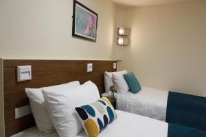 a hotel room with two beds and pillows at Hazeldean in Manchester