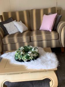 a living room with a couch and a table with flowers on it at Ruim appartement in oude bakkerij in Gasselternijveen
