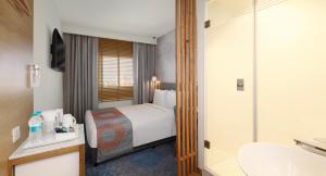 アーメダバードにあるHoliday Inn Express Ahmedabad Prahlad Nagar, an IHG Hotelのベッドとバスルーム付きのホテルルームです。