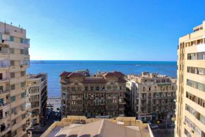 uma vista para uma cidade com edifícios e o oceano em Sea Star em Alexandria