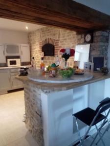 eine Küche mit einer Theke mit einer Steinmauer in der Unterkunft Spacieuse maison de mamie ! in Pouilly-en-Auxois