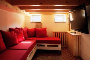 a living room with a red couch and a flat screen tv at Ferienhaus Schloßblick in Quedlinburg