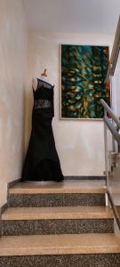a black dress hanging on a wall next to stairs at Am Meilenstein in Limburg an der Lahn