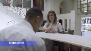 a man and a woman standing in front of a counter at Al-Mujeb in Kerak