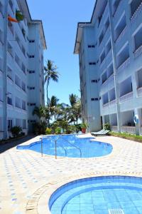 a swimming pool in front of a building at Rosy Sea Front Beach Condo in Bamburi