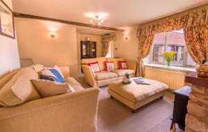 uma sala de estar com dois sofás e uma mesa em Valley View Farm Holiday Cottages em Helmsley