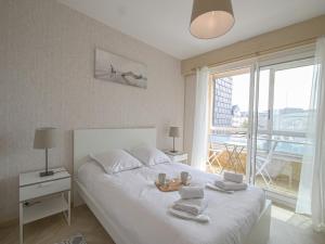 Le Gréement - Appt vue sur le port في كورسول-سور-مار: غرفة نوم بها سرير أبيض كبير مع مناشف عليه