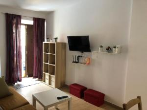 een woonkamer met een bank en een flatscreen-tv bij Aurorero Antonio in Arriate