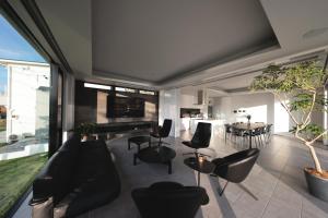 ein Wohnzimmer mit Sofa, Stühlen und einem Tisch in der Unterkunft GLテラス in Kyonan