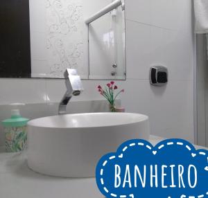 Baño blanco con lavabo y espejo en CASA LAR - Curta com a Família- A hora é agora, Venha, en Porto Belo